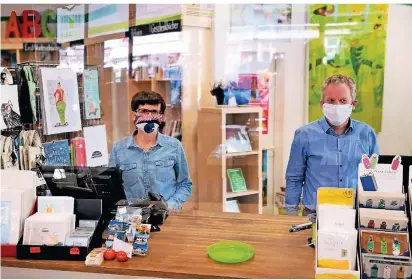  ?? FOTOS: MLAT ?? Julia Sander und Ansgar Barbers von der Buchhandlu­ng Barbers begrüßen ihre Kunden mit Mund-nasen-masken hinter Plexiglas.