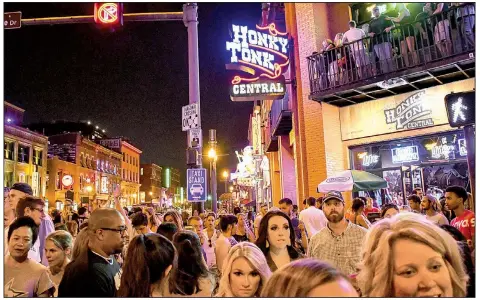  ??  ?? Saturday night crowds fill the streets of Nashville’s rowdy LoBro district, along Lower Broadway. Also known as the Honky Tonk Highway, the district is a blur of clubs and parties.