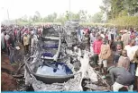  ?? —AFP ?? KISUMU: People stand next to a burnt out petrol tanker that burst into flames when it overturned in western Kenya, while a crowd thronged to collect the spilling fuel, on the busy highway between Kisumu and the border with Uganda, yesterday.
not survive,” Otieno said from his hospital bed.