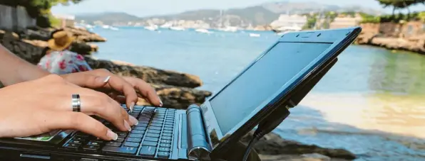  ?? Symbolbild: dpa ?? Mit dem Laptop am Strand statt daheim auf dem Sofa – für die meisten deutschen Angestellt­en wird das wohl vorerst ein Traum bleiben.