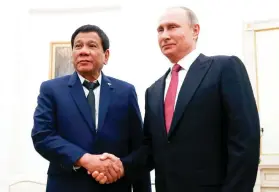  ?? POOL FOTO VIA AP ?? NEW ALLIES. Russian President Vladimir Putin, right, shakes hands with President Rodrigo Duterte during their meeting at the Kremlin in Moscow.