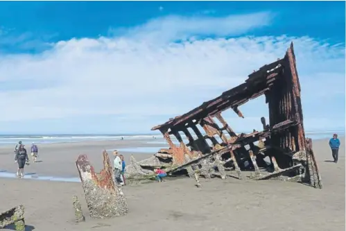  ?? Photos by Alex Pulaski, Chicago Tribune ?? The bare bones of the Peter Iredale, a British four-masted bark that ran aground in 1906, are a magnet for beach visitors to Fort Stevens State Park.