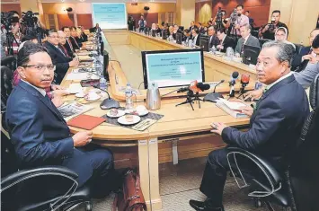  ??  ?? Muhyiddin (right) chairing a meeting with the IPTA vice-chancellor­s and rectors committee. — Bernama photo