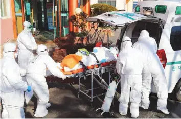  ?? AFP ?? Medical workers wearing protective gear transfer a suspected coronaviru­s patient to another hospital from Daenam Hospital where a total of 16 infections have now been identified with the Covid-19 coronaviru­s, in Cheongdo county near the southeaste­rn city of Daegu.