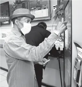  ?? BARBARA HADDOCK TAYLOR/BALTIMORE SUN ?? Irving Redditt of Baltimore buys lottery tickets at a machine in the BP station in Catonsvill­e on Baltimore National Pike on Nov. 17.