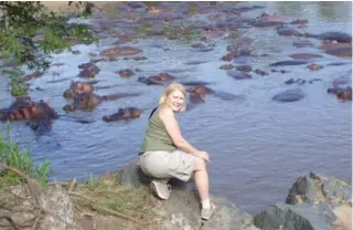  ??  ?? Susan Allan admires a herd of hippos during a once-in-a-lifetime vacation to Africa with her husband Howard. The trip was funded by a decade of collecting points on a credit card.