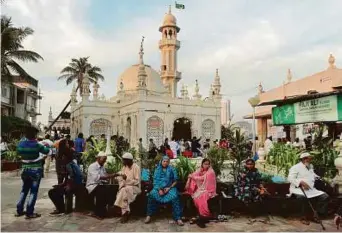  ??  ?? People are seen at the Haji Ali Dargah in Mumbai. The shrine has said it will scrap its 2012 order that stated it was a grievous sin to let women enter the sanctum sanctorum.