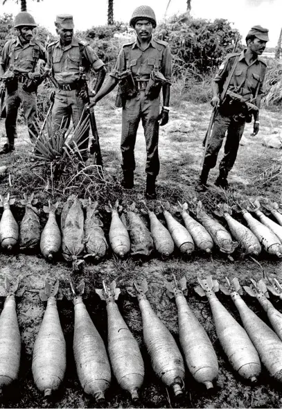  ??  ?? (LEFT) JA FFNA , SRI LAN KA 1987 Troops from the Indian Peace Keeping Force show off captured mortar shells from Tamil Tiger guerillas in Jaffna. Picture taken with a Nikon F3 and Nikkor 18mm f/3.5 lens