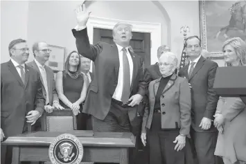  ?? ASSOCIATED PRESS ?? President Donald Trump waves after signing an executive order on health care in the Roosevelt Room of the White House in Washington.