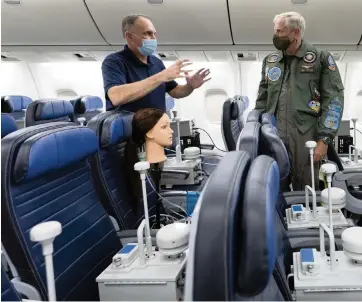  ?? STEPHENIE WADE U.S. Transporta­tion Command ?? Vice Adm. Dee Mewbourne, right, deputy commander of U.S. Transporta­tion Command, receives a descriptio­n of the airflow-particle test from David Silcott, chief executive of S3i, a research company, on board a United Airlines 767 in August.