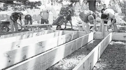  ?? KIM HAIRSTON/BALTIMORE SUN ?? Volunteers build an education area outside North Bend Elementary School. Principal Patricia Burrell applied to nonprofit Kaboom’s program three years ago. She said the previous playground had become rundown and unsafe for the southwest Baltimore students.