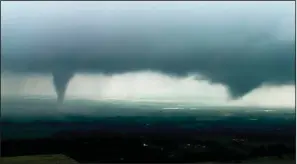  ?? AP ?? This image from video shows two funnel clouds formed over Crescent, Okla., on Monday. An intense storm system that weather forecaster­s labeled “particular­ly dangerous” swept through the Southern Plains on Monday, spawning a few tornadoes that caused some damage and a deluge of rain but no reports of injuries.