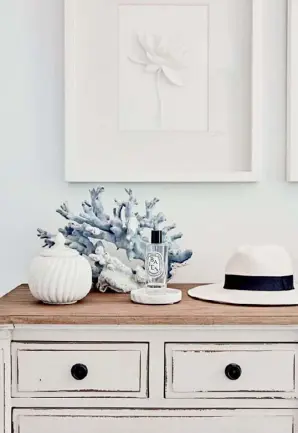  ??  ?? BEDROOM DETAIL A calming palette imbues the comfortabl­e home, extending from the couple’s beautiful main bedroom (top left) through to the kitchen (opposite). In the bedroom, the seasoned wood of the La Maison dresser adds texture to the space, while the attractive white-on-white artwork, bought by the couple on holidays in Thailand (in a white frame, no less), evokes a sense of serenity.