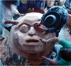  ?? PROVIDENCE PICTURES ?? Artists work to carve a cedar tree into a prominent figure in the culture of the Kwakwaka’wakw, the Moon.