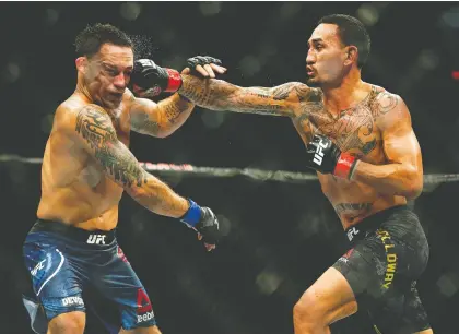 ?? LARRY WONG ?? Max Holloway, right, defeated Frankie Edgar by unanimous decision in a five-round UFC featherwei­ght title bout at UFC 240 Saturday at Rogers Place. The judges had it 50-45, 49-46 and 48-47, showing the razor-thin margin of victory in each round.