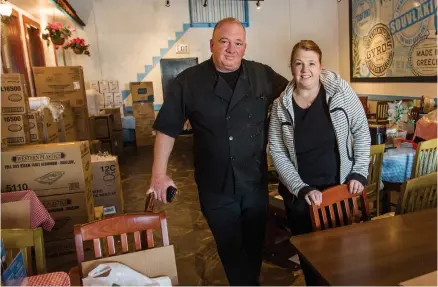  ?? BOB TYMCZYSZYN TORSTAR ?? Pierre Kountouris and Cathy Kountouris-McCormack from Joe Feta’s Greek Village restaurant stand inside their dining room, now packed with takeout cartons. “I miss seeing the people come in ... we’re all about the people,” says Kountouris.