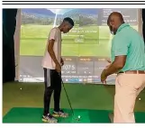  ?? CONTRIBUTE­D ?? William Ware, coach of the budding golf program at Wilberforc­e University, works with Patrick Rukundo, a freshman from Dunbar High School, at a golf simulator.