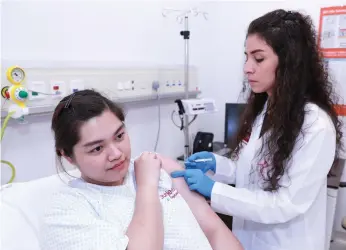  ?? Victor Besa / The National ?? Dr Safaa Malkat injects a patient with a flu vaccine at Burjeel day centre on Reem Island. There is expected to be much demand for vaccines during the coming flu season