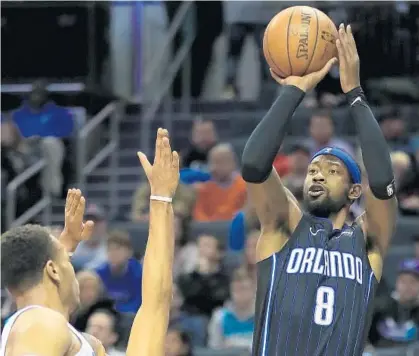  ?? STREETER LECKA/GETTY ?? The Orlando Magic’s Terrence Ross, right, shoots over the Charlotte Hornets defense Monday at Spectrum Center in Charlotte, N.C.