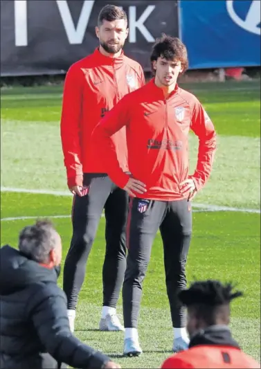  ??  ?? João Félix, delante de Felipe, atiende antes de empezar un ejercicio durante la sesión de ayer en el Cerro.