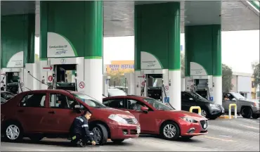  ?? PHOTO: AP ?? An employee of a BP petrol station attends to a customer on the outskirts of Mexico City. BP shares surged the most this year after a London newspaper reported on rumours that Exxon Mobil sounded out major shareholde­rs over a potential takeover.