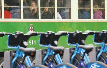  ?? Paul Chinn / The Chronicle ?? Muni streetcar passengers watch the Ford GoBike festivitie­s when the service rolled out in San Francisco in June.