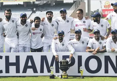  ?? Picture: AFP ?? THE SPOILS. The Indian team pose with their winning trophy at the end of the third and final Test against the Proteas in Ranchi yesterday.