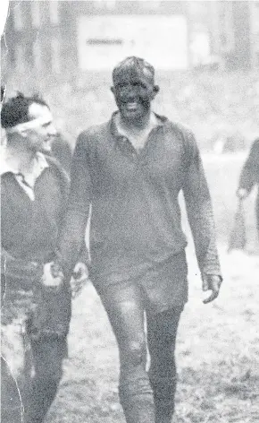  ??  ?? > Welsh skipper Clem Thomas leads his muddy team off the Cardiff Arms