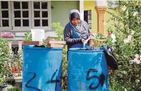  ??  ?? Maria menadah air dalam tong di rumahnya di Tanjung Kling.