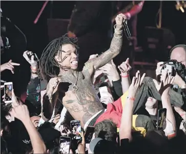  ?? Photograph­s by Wally Skalij Los Angeles Times ?? RAE SREMMURD, above, surfs the crowd during a memorial concert for the late rapper Mac Miller at the Greek Theatre on Wednesday night. Among the artists performing were, top left, Miguel, and top right, SZA.