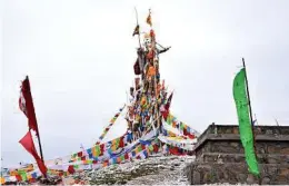  ??  ?? An arrangemen­t of Tibetan prayer flags on a hill above Hezuo.