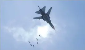  ??  ?? QABUN, Syria: A Syrian government forces’ MiG-23 fighter-bomber drops a payload during a reported air strike in the rebel-held area of Qabun, east of the capital Damascus yesterday.— AFP