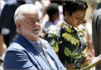  ?? CHRIS PIZZELLO — THE ASSOCIATED PRESS ?? Filmmaker George Lucas, left, and his wife Mellody Hobson listen to remarks at a news conference outside Los Angeles City Hall on Tuesday. The Los Angeles City Council approved preliminar­y steps that will allow constructi­on of the $1.5 billion Lucas...