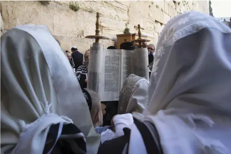  ?? Reuters ?? Jews read from the Torah at the Western Wall in Jerusalem. Israel’s far right wants Hebrew law to form a judicial basis
