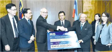  ??  ?? Shafie (fourth left) witnesses the handing over of the mock cheque by Hashim (third right) to Thien.
