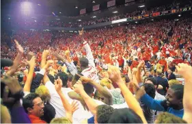  ?? GREG SORBER/JOURNAL FILE ?? At center, New Mexico forward Rob Newton raises a finger to the sky as fans rush the court after UNM beat top-ranked Arizona 32 years ago.