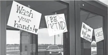  ?? PHOTOS BY ERIN BORMETT/USA TODAY NETWORK ?? Signs with encouragin­g messages greet families as they pull up to the front doors of Parkston Elementary School to get the week's homework on Saturday in Parkston, S.D.