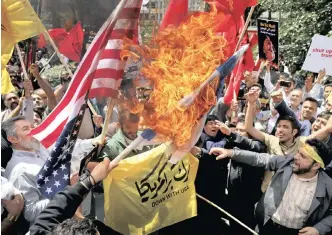  ?? PICTURE: AP/EBRAHIM NOROOZI/AFRICAN NEWS AGENCY (ANA) ?? Iranian protesters burn representa­tions of the flags of Israel and the US at a gathering at the former US embassy in Tehran this week. Hundreds of hardliners gathered at the former embassy to show their anger over the death of dozens of Palestinia­ns...