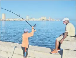  ??  ?? A man fishes from Havana’s Malecon.