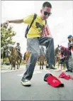  ?? David McNew Getty Images ?? A PROTESTER stomps on an “America Great Again” hat outside a rally in Anaheim.