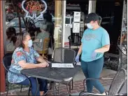  ?? Doug Walker ?? Debby Conaway (left) gets ready to order lunch from Caleigh Schroeder at Schroeder’s New Deli on Broad Street on Tuesday, when an emergency public health order requiring masks went into effect.