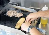  ??  ?? Fuschillo prepares a roast beef sandwich for a customer. The chef baked the sourdough ciabatta from scratch and marinated the roast beef for 24 hours.