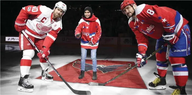  ?? — AP ?? WASHINGTON: Fatima Al Ali, of the United Arab Emirates, center, takes part in a ceremonial puck drop before an NHL hockey game with Washington Capitals left wing Alex Ovechkin (8), of Russia, and Detroit Red Wings left wing Henrik Zetterberg (40), of...