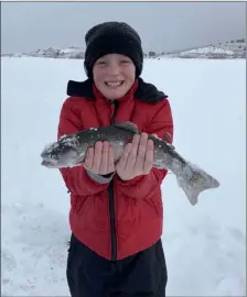  ?? Lee Jenkins ?? Austin Jenkins,
12, holds up a plump rainbow trout he pulled through the ice at Utah’s Panguitch Lake, on a family trip called “Man Camp.”