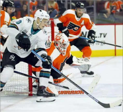  ?? TOM MIHALEK — THE ASSOCIATED PRESS ?? The Sharks’ Antti Suomela attacks the goal as Flyers’ goalie Brian Elliott tries to break up the attempt during the third period Tuesday night. Things did not go Elliott’s way in an 8-2 San Jose win.