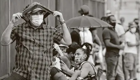  ?? Melissa Phillip / Staff photograph­er ?? Gabino Acosta covers his head with a bandanna as he waits for free COVID-19 testing conducted by United Memorial Medical Center at the Consulate General of Mexico on Sunday. The surge in cases has been met with a renewed fervor to find tests.