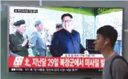  ?? THE ASSOCIATED PRESS ?? A man at the Seoul Railway Station in Seoul, South Korea, on Sunday passes by a TV news program showing a file image of North Korean leader Kim Jong Un.