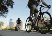  ?? Elizabeth Conley / Houston Chronicle ?? A cyclist rides from downtown during rush hour on Monday. Fewer people are biking to work here.