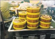  ??  ?? At the Milpitas Koi Palace, a dim sum cart is stacked with dumpling-filled steamer baskets.