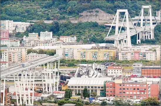  ??  ?? Cars are blocked on the Morandi highway bridge after a section of it collapsed, in Genoa, northern Italy, on Aug 14. A large section of the bridge collapsed over an industrial area in the Italiancit­y of Genoa during a sudden and violent storm, leaving vehicles crushed in rubble below. (AP)